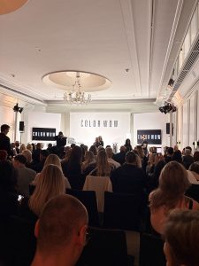 Friseur_Bonn_Laurentius_Color_Wow_event - Friseur Bonn ❤️ Laurentius Excellence in Hair ⭐ Audience seated in a ballroom watching a Color Wow presentation on stage with large COLOR WOW signage behind the speakers.